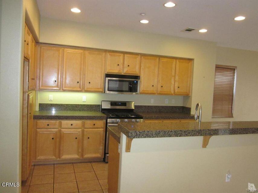 1731 Sonata Drive Oxnard, CA 93030 - Photo 4 of 13 a kitchen with granite countertop white cabinets and stainless steel appliances