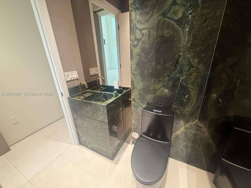 135 Southwest 29th Road Miami, FL 33129 - Photo 16 of 47 a bathroom with a granite countertop sink a toilet and a mirror