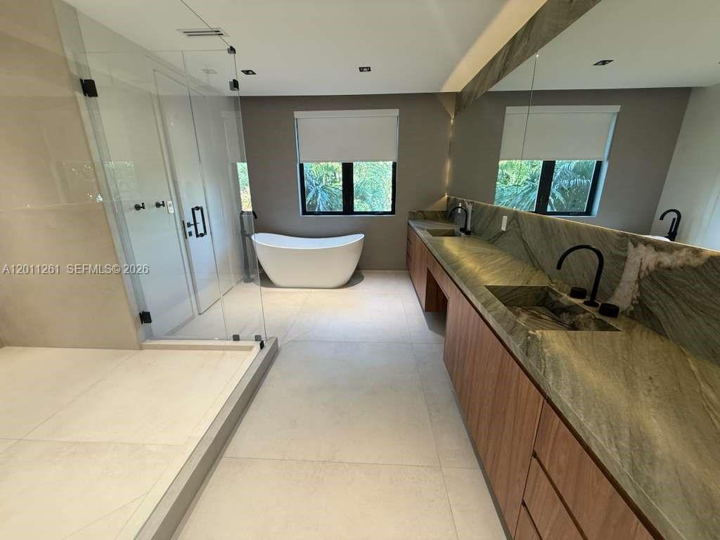 135 Southwest 29th Road Miami, FL 33129 - Photo 33 of 47 a large bathroom with a granite countertop sink a mirror and a bathtub