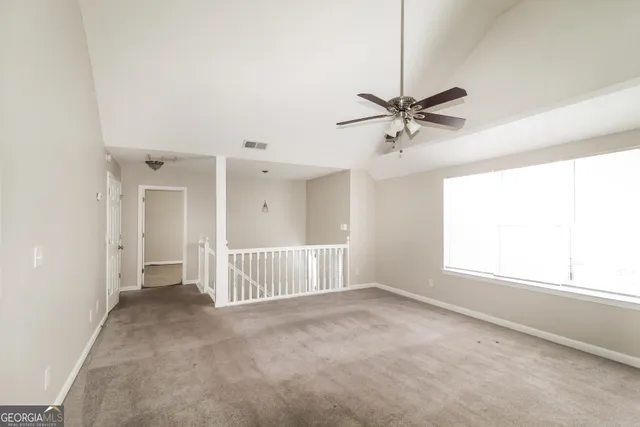 an empty room with a window and a ceiling fan