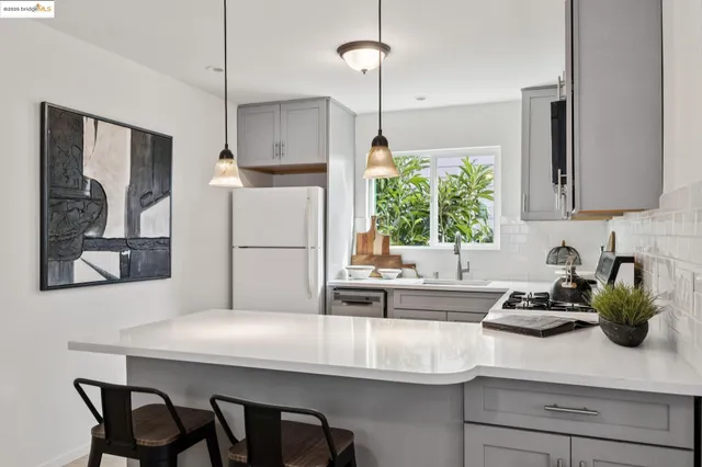 a kitchen with a sink refrigerator and cabinets