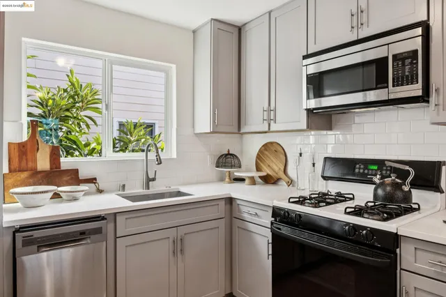 a kitchen with stainless steel appliances a stove a sink a microwave and cabinets