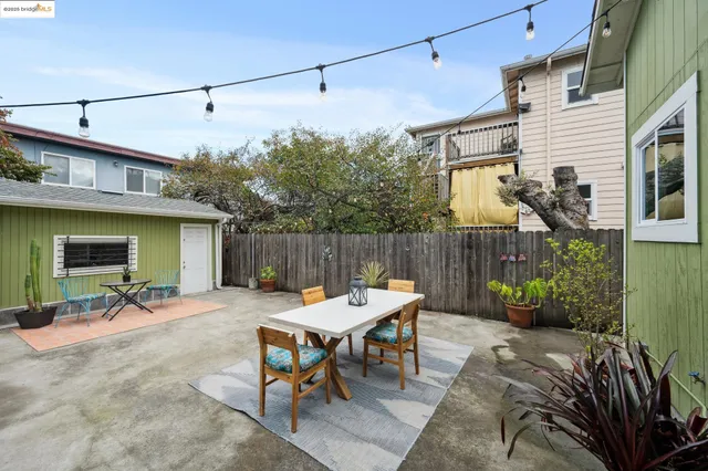 a view of a patio with table and chairs with wooden fence and plants