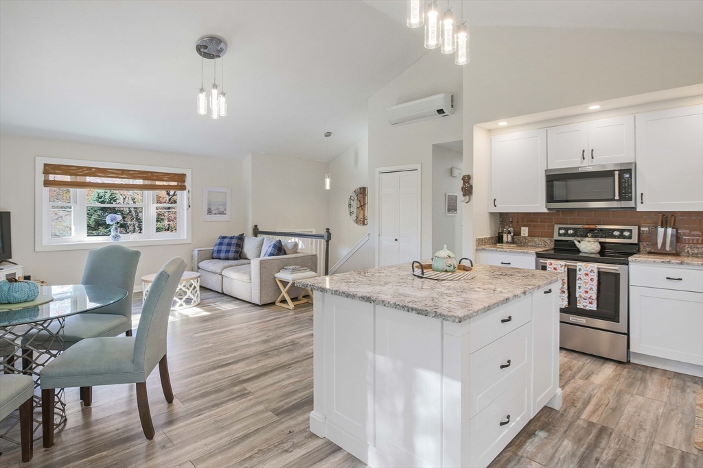 96 Indian Hill Road Worcester, MA 01606 - Photo 10 of 42 a open kitchen with stainless steel appliances granite countertop a stove oven a sink dishwasher a dining table and chairs with wooden floor