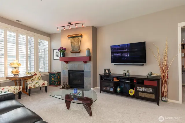 a living room with furniture kitchen view and a large window