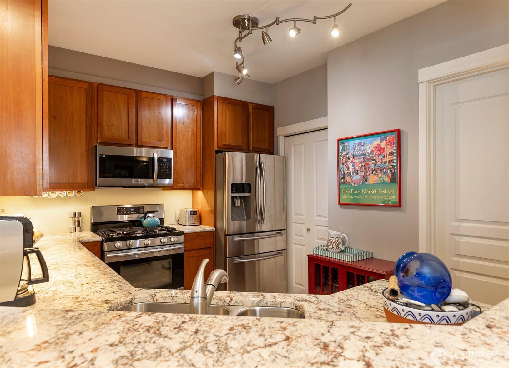 2000 Alaskan Way, Unit 255 Seattle, WA 98121 - Photo 7 of 31 a kitchen with stainless steel appliances kitchen island granite countertop a refrigerator stove and oven with wooden floor