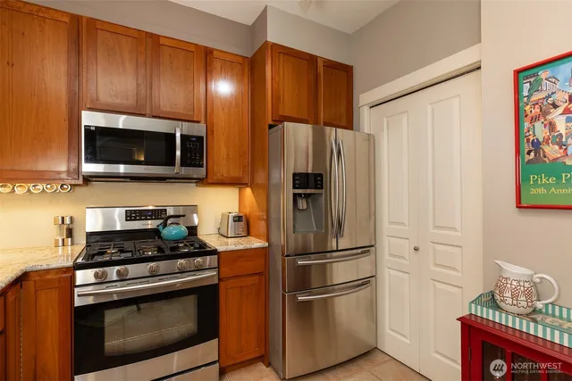 a kitchen with kitchen island granite countertop a sink and refrigerator