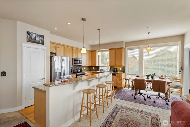 a very nice looking living room with a large window and stainless steel appliances