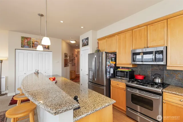 a kitchen with stainless steel appliances granite countertop a sink refrigerator and cabinets