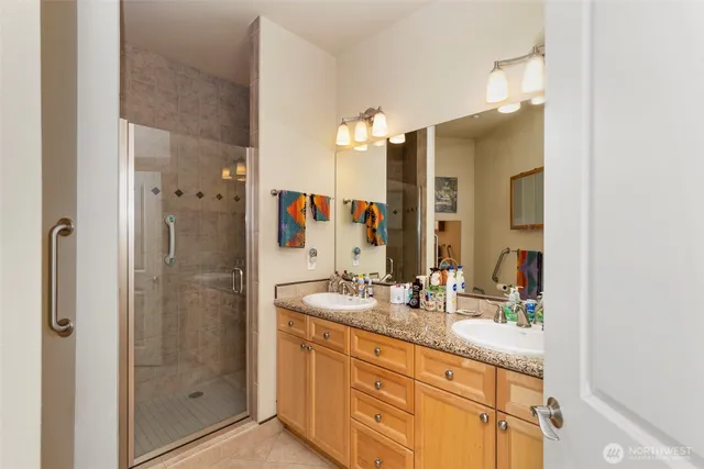 a bathroom with a granite countertop sink mirror and shower