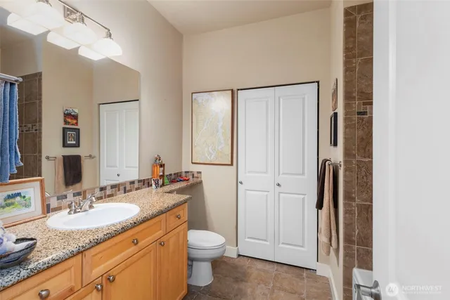 a bathroom with a granite countertop sink toilet and shower