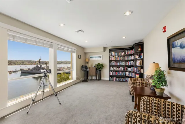 a living room with furniture a rug and gym equipment