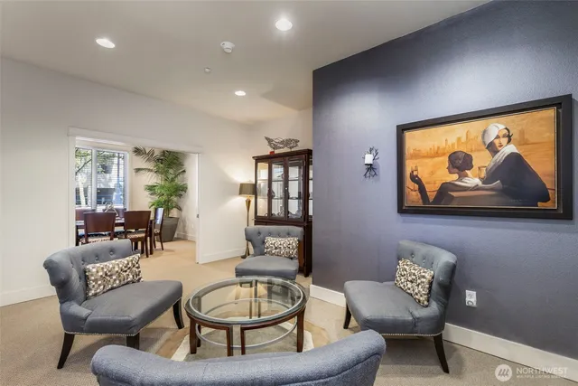a living room with furniture a rug and a wall painting