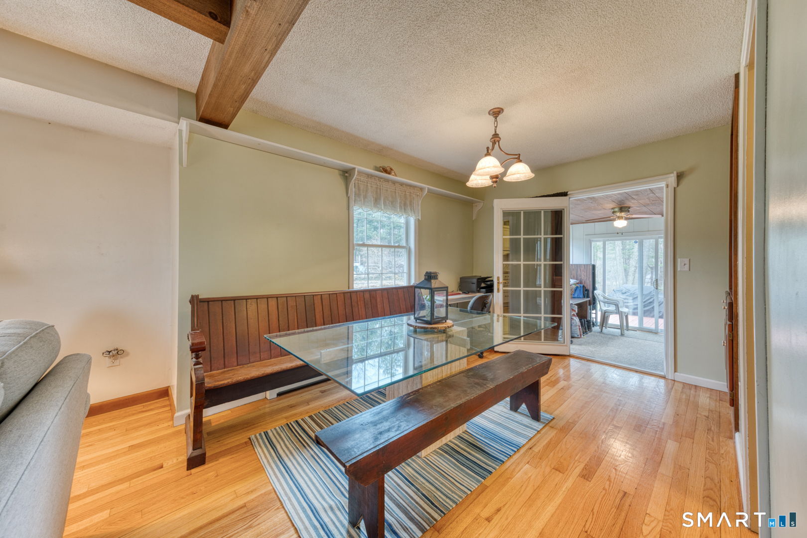 454 Providence Turnpike Hampton, CT 06247 - Photo 26 of 40 a living room with a dining table wooden floor and a chandelier