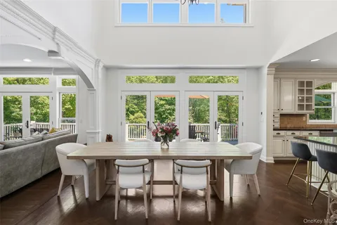 a kitchen with stainless steel appliances kitchen island granite countertop a stove top oven a sink dishwasher a dining table and chairs with wooden floor