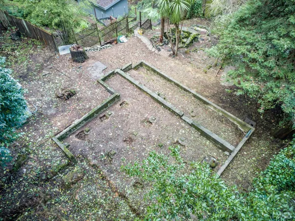 a view of a yard with wooden fence