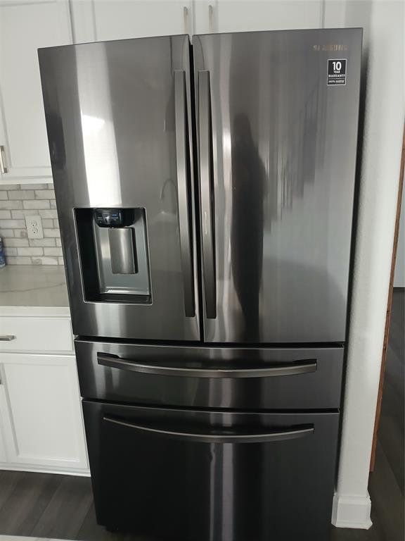 8045 Ballater Drive Fort Worth, TX 76123 - Photo 14 of 26 Kitchen view of stainless steel fridge with ice dispenser, decorative backsplash, white cabinetry, and light countertops