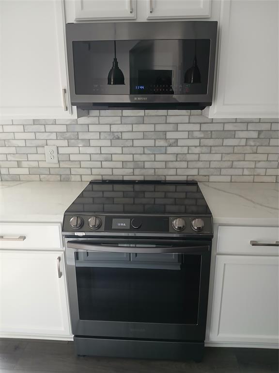 8045 Ballater Drive Fort Worth, TX 76123 - Photo 15 of 26 Kitchen with electric range oven, white cabinets, and light stone counters