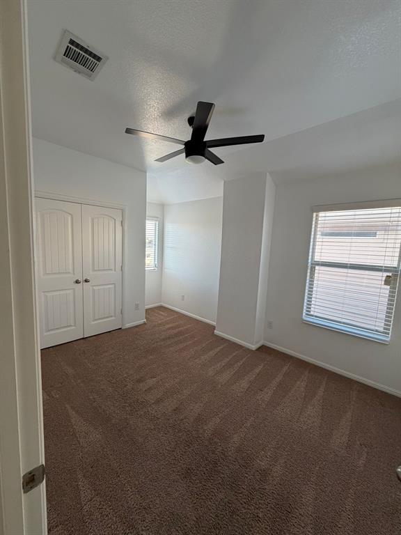 8045 Ballater Drive Fort Worth, TX 76123 - Photo 22 of 26 Unfurnished bedroom featuring a textured ceiling, dark colored carpet, ceiling fan, and a closet