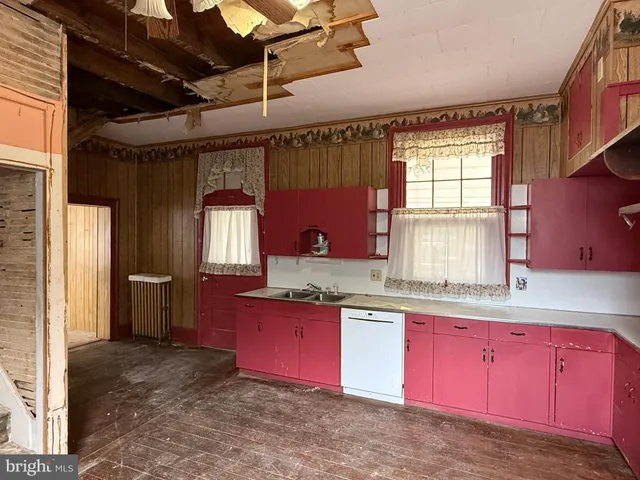 a kitchen with granite countertop a sink stove and cabinets