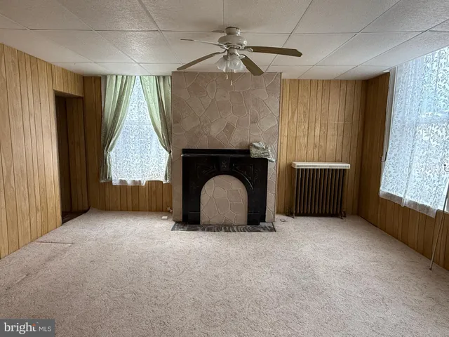 an empty room with windows and fireplace