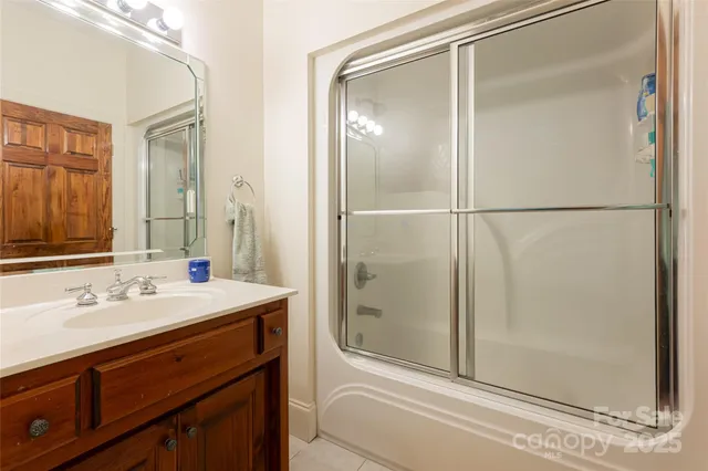 a bathroom with a shower sink and mirror