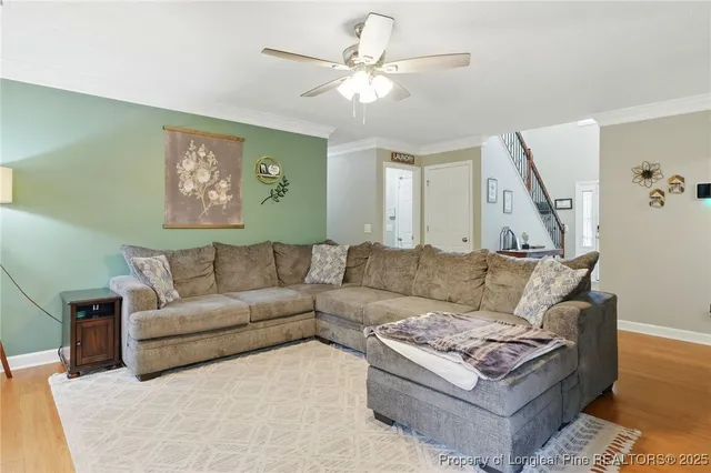 a living room with furniture and a ceiling fan