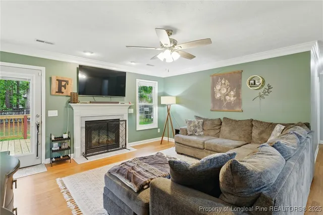 a living room with furniture a flat screen tv and a fireplace