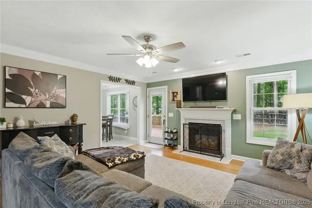 a living room with furniture a flat screen tv and a fireplace