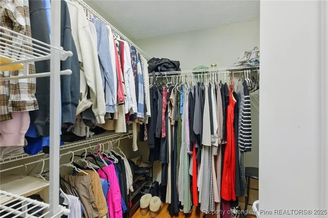a view of walk in closet with clothes