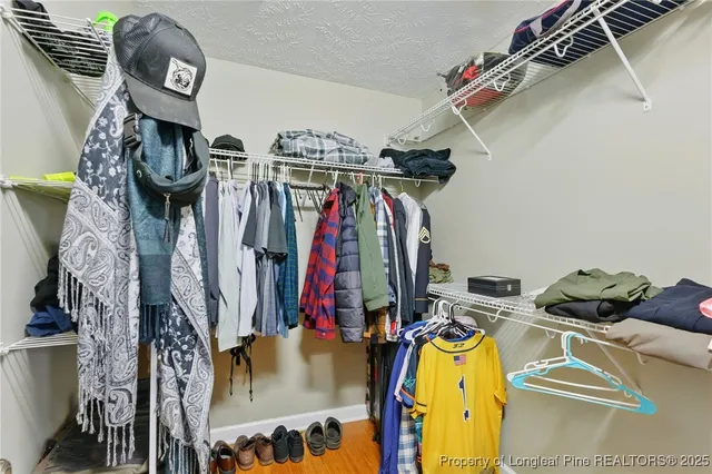 a view of walk in closet with clothes and shoes