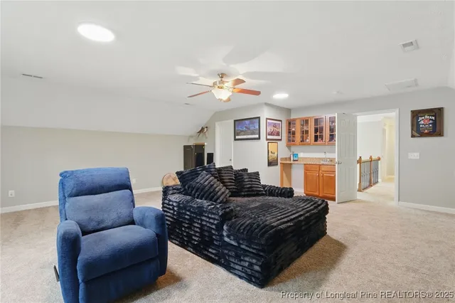 a living room with furniture ceiling fan and a rug