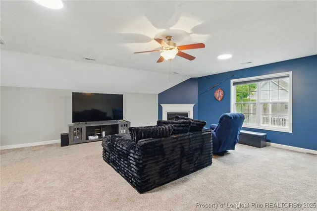 a living room with furniture a flat screen tv and a large window