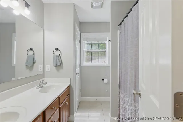 a bathroom with a double vanity sink a mirror and a shower
