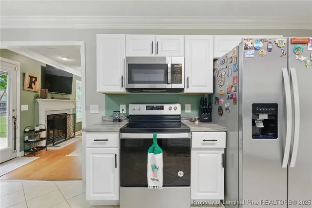 a kitchen with granite countertop a stove top oven microwave and refrigerator