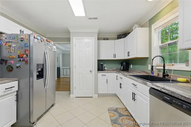 a kitchen with granite countertop a refrigerator and a sink