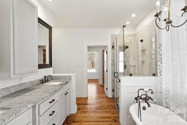 a spacious bathroom with a granite countertop sink mirror and a shower