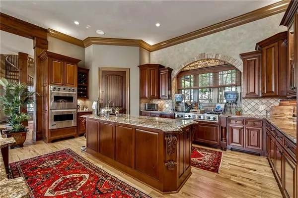 a living room with furniture a fireplace and floor to ceiling windows