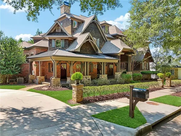 a front view of a house with garden and trees