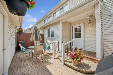 a view of a patio with couches table and chairs and potted plants