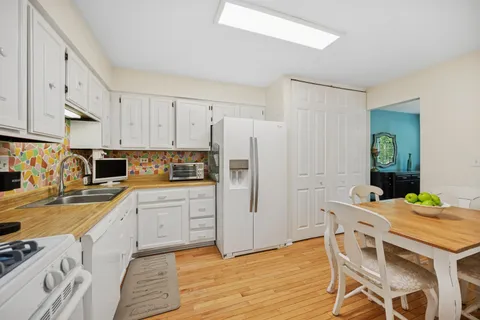 a kitchen with stainless steel appliances granite countertop a white cabinets and wooden floor