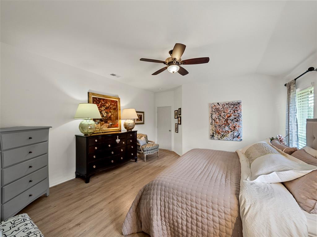 204 Arbor Ridge Drive Allen, TX 75002 - Photo 17 of 36 Spacious bedroom featuring wood-finish flooring, a ceiling fan with integrated lighting, and multiple windows with blinds