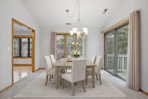a view of a dining room with furniture large windows and wooden floor