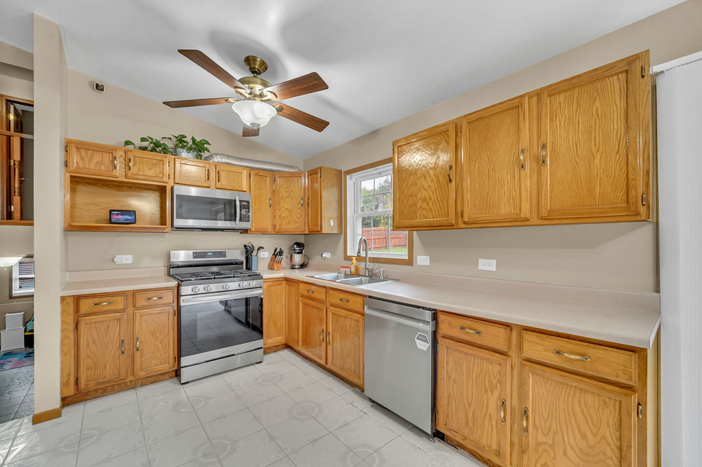4013 Ridge Road Zion, IL 60099 - Photo 8 of 23 a kitchen with stainless steel appliances granite countertop a sink dishwasher stove top oven and cabinets