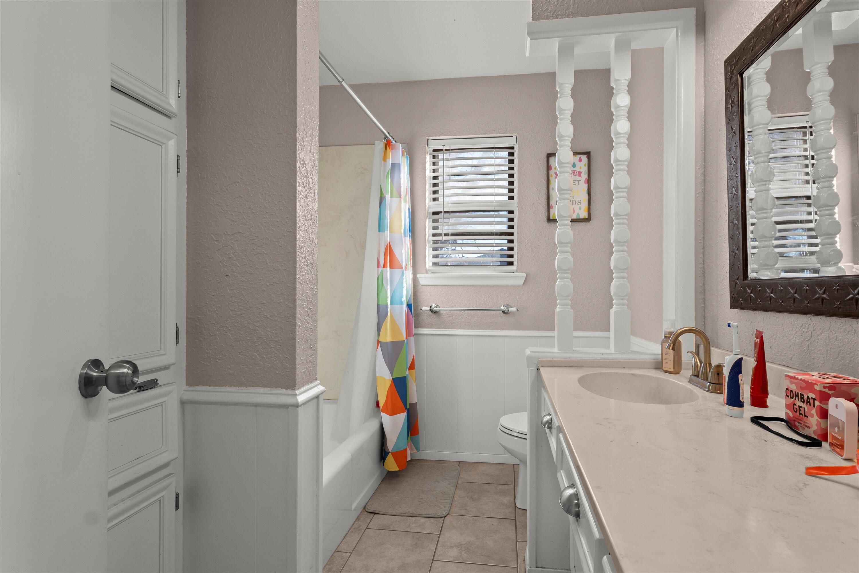 1007 South Howell Street Brownfield, TX 79316 - Photo 14 of 18 a bathroom with a sink vanity tub and shower