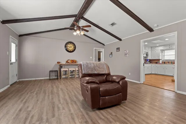 a living room with furniture and a wooden floor