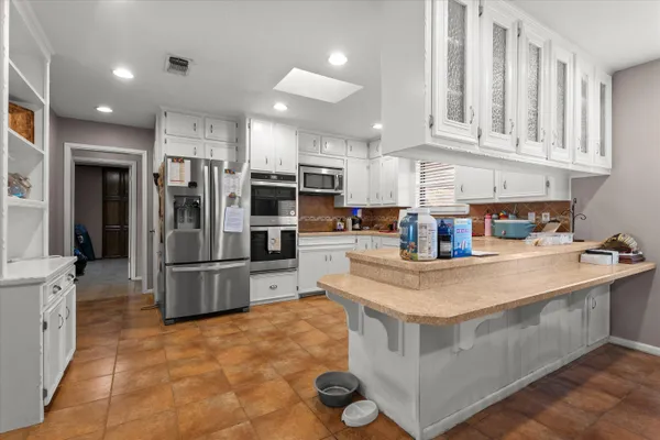a kitchen with stainless steel appliances granite countertop a refrigerator a stove and a sink