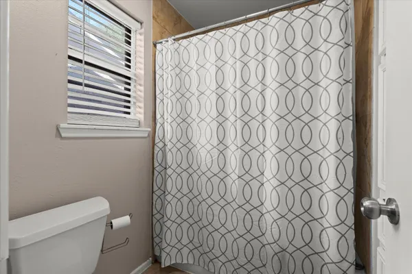 a white toilet sitting next to a shower curtain