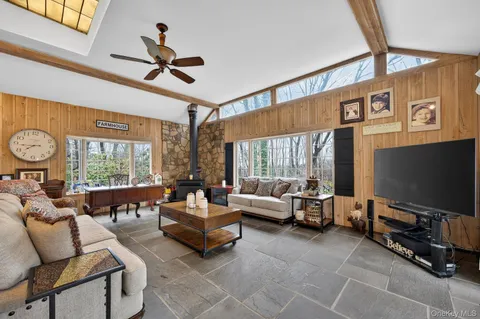 a living room with furniture ceiling fan and a window