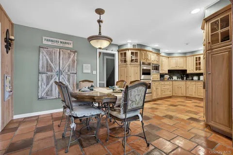 a view of a dining room and livingroom with furniture wooden floor a chandelier